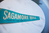 Close-up of the cream lettering and vintage texture on a teal Sagamore Hill felt flag.