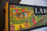 Colorful depiction of indigenous life, including figures and a horse, on vintage felt pennant.