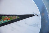 Detail of the black felt pennant's tapered end, showing green and orange graphics.