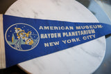 Section of vintage blue felt banner with AMERICAN MUSEUM- text and soft texture.