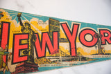 Vintage New York City felt pennant showing 'W YORK' letters, United Nations, and Coney Island.