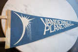 Vintage blue felt pennant with white solar eclipse graphic viewed from an angle.