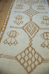 Angled detail of distressed Kars runner's ivory field, soft camel diamond motifs, and zig-zag border.