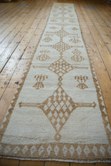 Textured ivory pile and camel diamond border pattern on a distressed Kars runner.