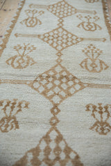 Textured pile of a vintage Kars runner, featuring ivory and brown geometric floral patterns.