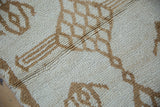 Distressed Kars rug's short pile with textured ivory and camel geometric design.
