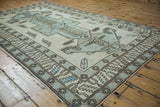 Distressed vintage Oushak carpet's powder blue geometric patterns, ivory field, faint foundation showing.