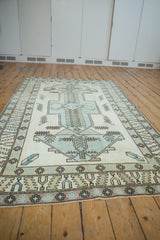 Detail of distressed Oushak rug, showing powder blue geometric border and time-softened ivory field.
