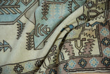 Folded vintage Distressed Oushak carpet with pale blue, ivory, and mauve geometric patterns.