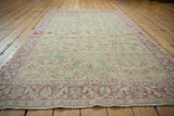 Low angle view of a vintage Sparta rug, showing its full length and soft-toned floral design.