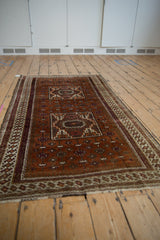 Rust field with vinery, stepped medallion, geometric border, and intact side cord selvage.