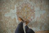 Textured pile of a vintage distressed Oushak rug with muted mocha, ivory, and mint tones.