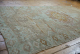 Distressed texture, faded mocha, mint green, and pink geometric patterns of this Oushak runner.