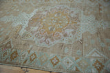 Decorative distressed Oushak rug runner with faded mocha, mint green, and pink floral motifs.