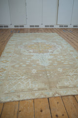 Distressed vintage Oushak runner with visible abrashes, soft mocha, ivory, and pink hues.