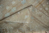 Distressed light mocha pile and tightly woven foundation of a vintage Oushak rug.