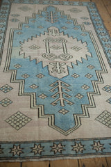 Distressed sky blue and dusty mauve Oushak rug, showing serrated geometric plant motifs.
