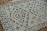 Distressed Kars runner featuring an arrowed main border and geometric ivory and coffee brown patterns.