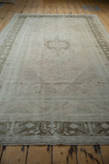 Distressed Oushak carpet from a low angle, showing its soft pile and faded rose tones.