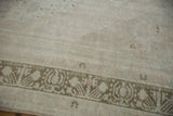 Detail of the distressed short pile and sage green geometric border on a vintage Oushak rug.
