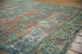 Angled view of vintage Lilihan carpet showing faded dusty peach and blue floral patterns with visible wear.