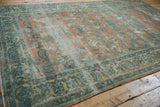 Distressed vintage Lilihan carpet, showing faded peach and blue floral patterns with worn texture.