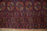 Vintage Turkmen rug with geometric floral guls, detailed borders, and tattered fringe.