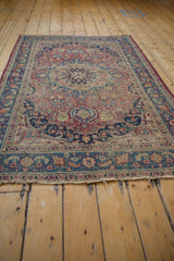 Tattered fringe and floral border of a vintage Meshed rug with cochineal red and navy.