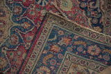 Hand-knotted foundation and dusty red, blue floral motifs on a vintage Meshed rug corner.