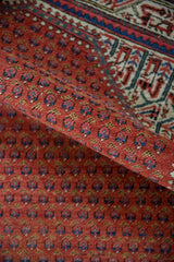 Curved Vintage Mir Sarouk rug with brick red boteh field and geometric main border.