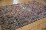 Vintage Meshed rug's roundel medallion, trefoil finials, and floral field with visible foundation wear.