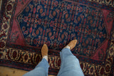 Lifestyle view of the vintage Lilihan rug's rich indigo and wine red Herati design.