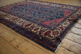 Vintage Lilihan rug corner showing the ruby spandrel and wide ivory floral border.