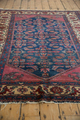 Angled view highlighting the deep indigo pile and detailed border of a vintage Lilihan rug.