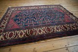 Angled perspective of a vintage Lilihan rug showing its traditional layout with a rich indigo and ruby palette.