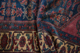 A folded view of a vintage Lilihan rug highlighting the rich indigo field and ivory border.