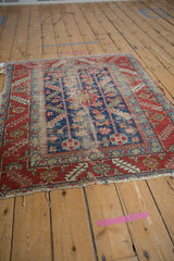 Age-softened indigo field of antique Heriz rug, displaying serrated leaves and pinwheel blossoms.