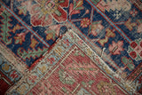 Worn pile, tatter, and exposed hand-knotted foundation of the antique Heriz rug.