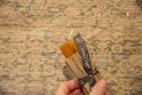 Hand holding terra cotta 6 inch beeswax taper candles with Greentree Home ribbon.