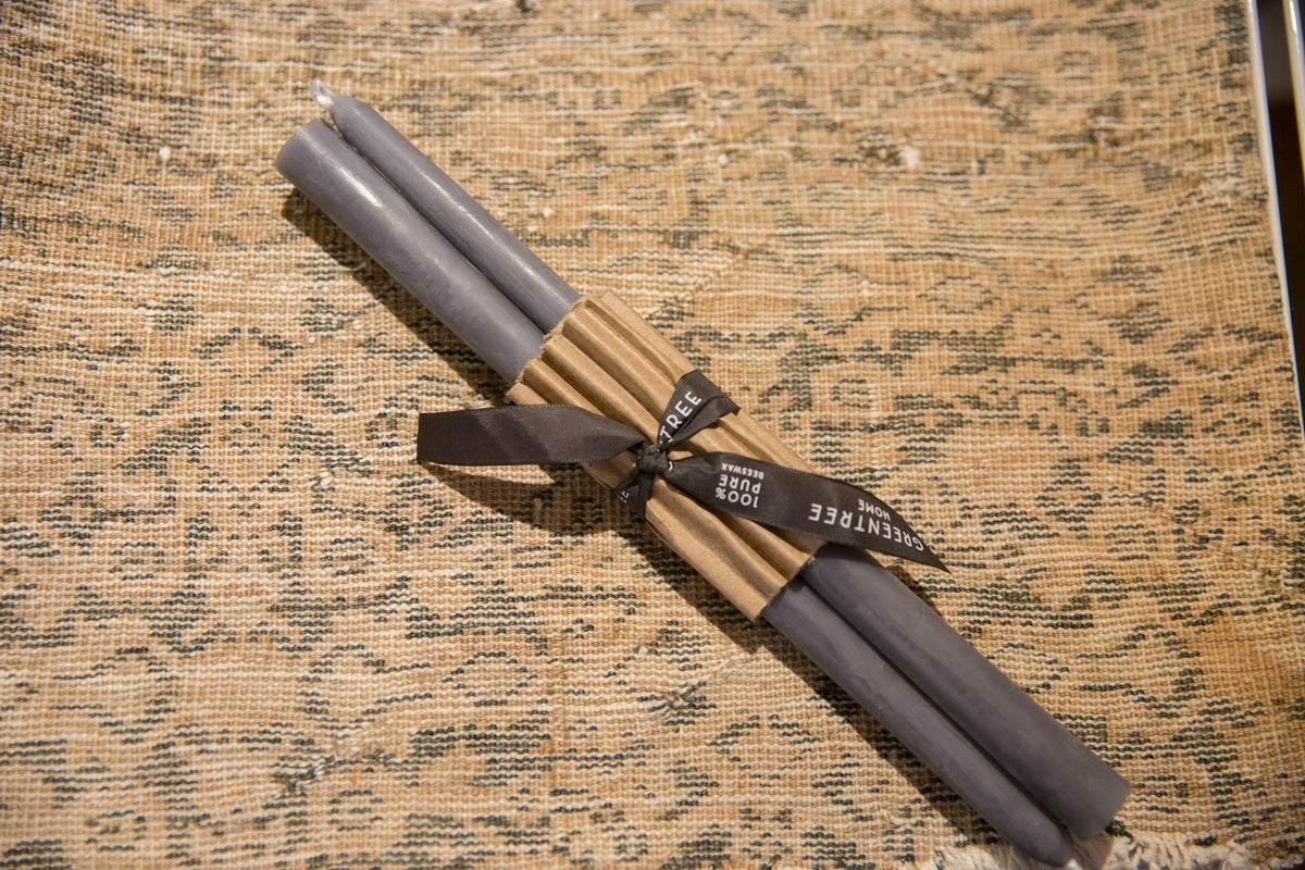 Gray 12-inch beeswax taper candles, bundled in brown paper with a branded black ribbon.