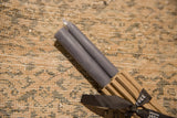 Gray beeswax taper candles, showing wicks and their subtle, hand-poured texture.