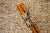 Terra cotta rope design beeswax taper candles bundled with brown paper and black ribbon.