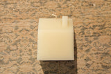 Cream beeswax house candle rooftop with white wick and chimney detail.