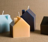 Multiple large house beeswax candles in natural, light blue, and dark blue shades.