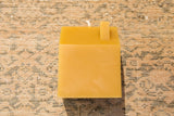 Natural beeswax house candle with white wick and chimney top.