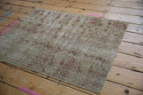 Antique Distressed Kerman rug with worn ivory and red boteh motifs, foundation visible.