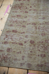 Visible foundation and worn pile of the antique Kerman fragment, with faded blush boteh motifs.