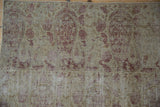 Distressed pile of Antique Kerman rug fragment with faded boteh and visible foundation.