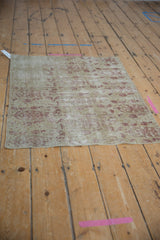 Distressed antique Kerman fragment, with faded blush boteh design and exposed foundation.