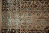 Distressed Hamadan rug detail showing worn Herati pattern, visible foundation, and blue selvage.